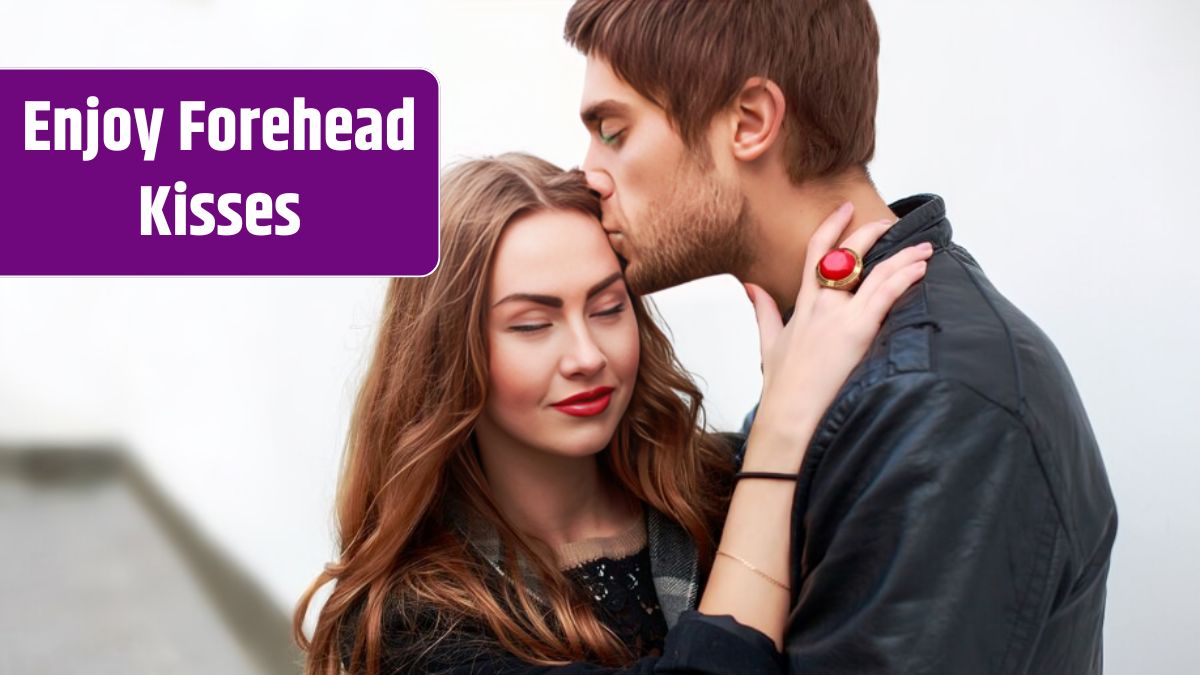 Romantic boy hugging and kissing his girlfriend's forehead.