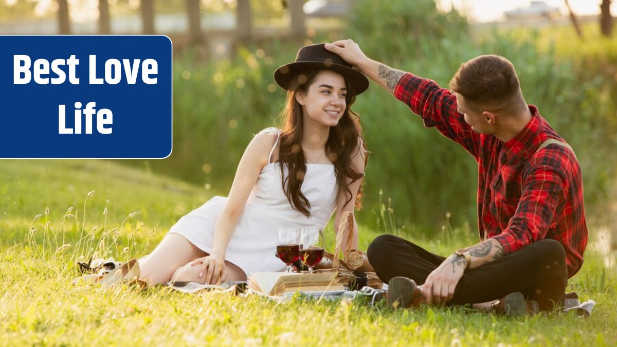 Young and happy couple enjoying a picnic spread on parkside in summer day.